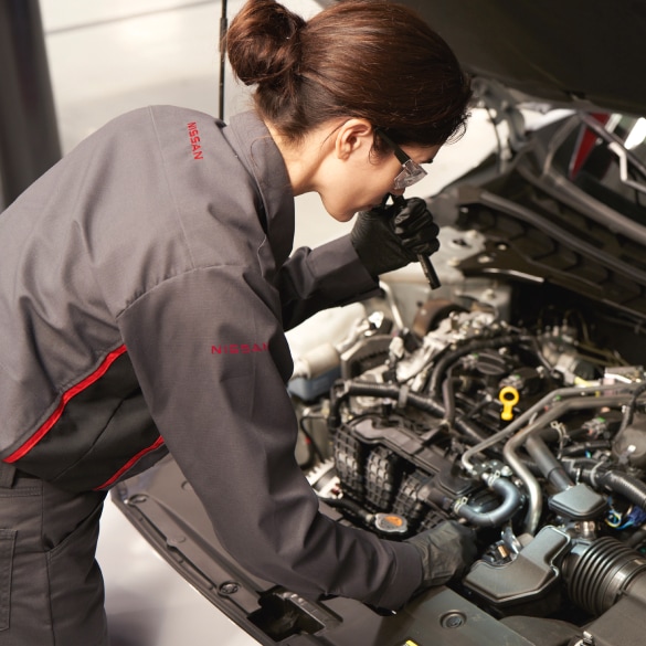 A  woman service technician checking Nissan's car engine